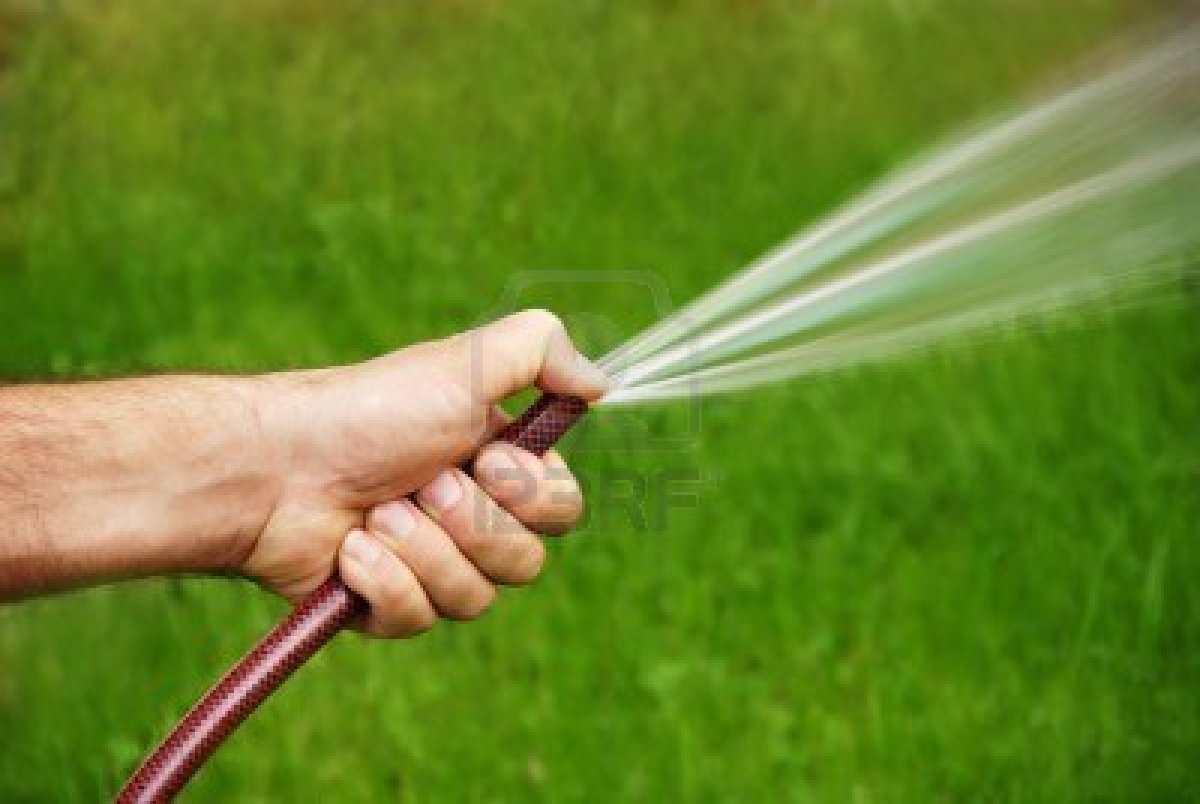 7628732-male-hand-with-a-hose-watering-grass